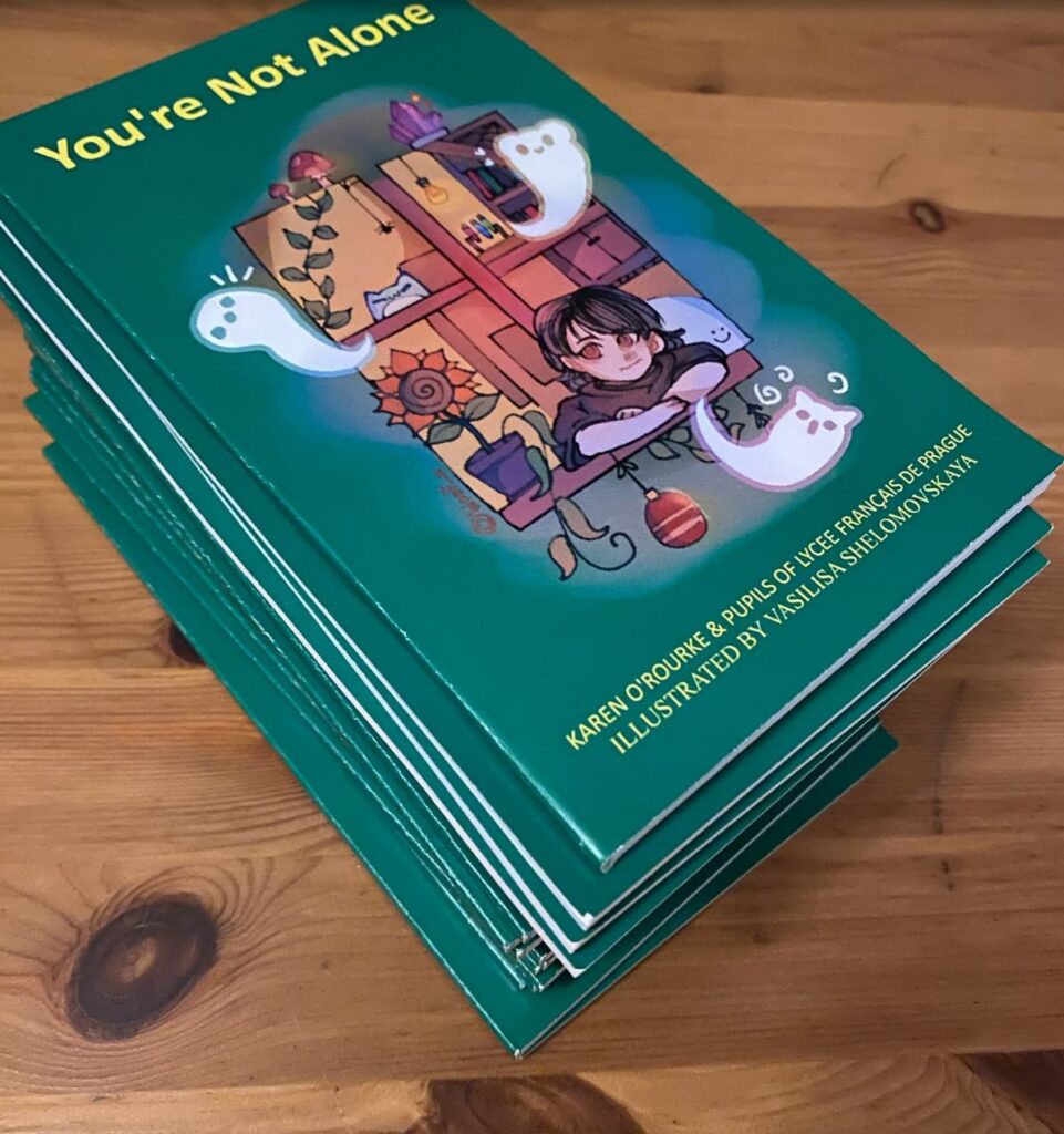 Stack of printed copies of the teal book You're Not Alone