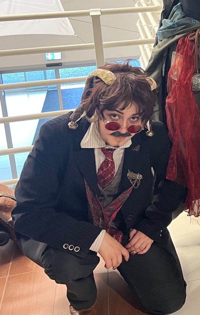 School blazer and tie worn with clown make-up, bells and a ruffled collar
