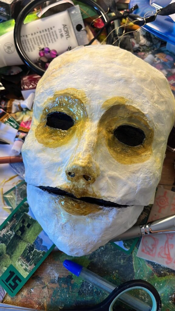 Mask with gold-rimmed eyes and a black painted moustache