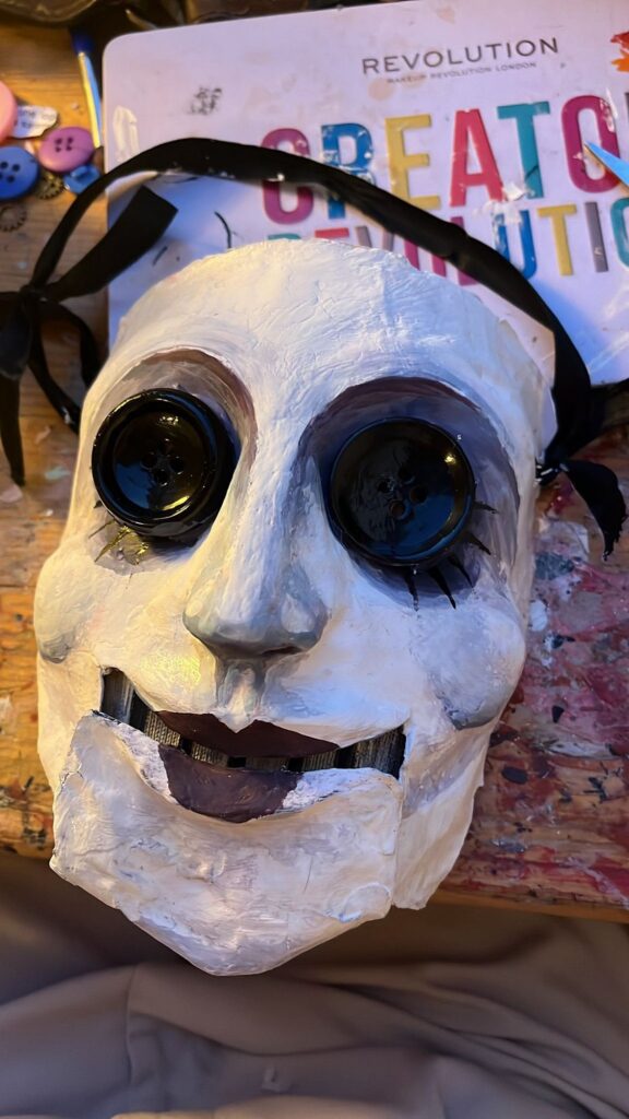 Mask with large black goggle eyes and an open jaw